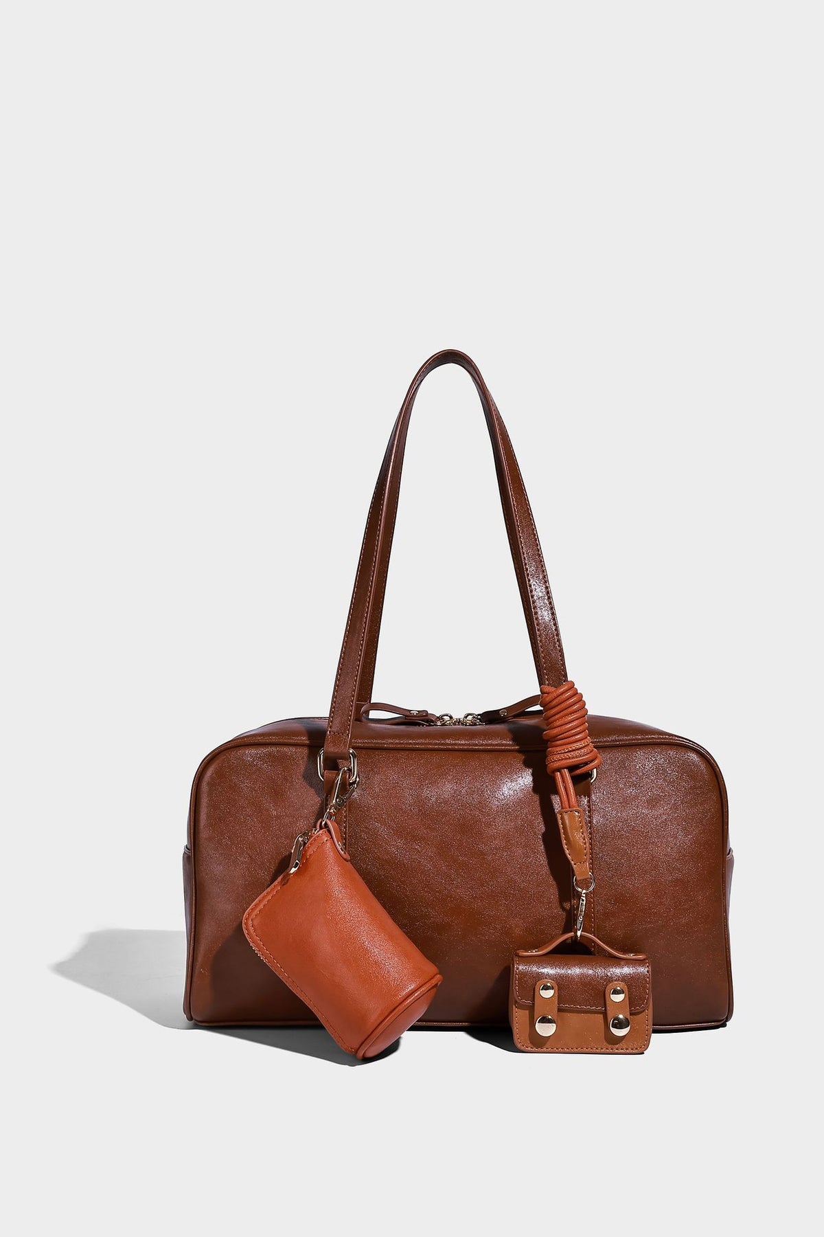 Strukturierte Boston-Schultertasche in glänzender Lederoptik mit zwei langen Trageriemen, Reißverschluss oben, goldfarbenen Beschlägen und zwei