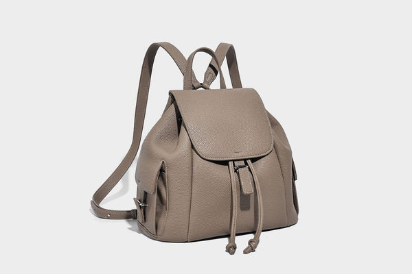 Compact pebbled leather-look flap drawstring backpack handbag with side pockets, top handle, and silver-tone hardware, detail