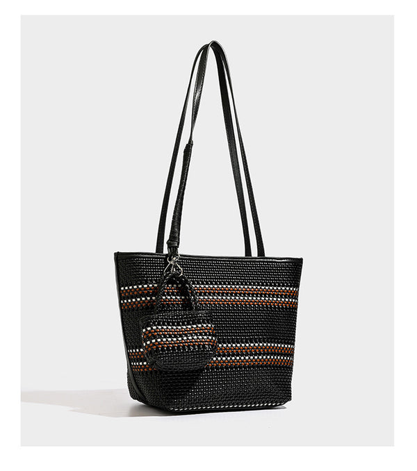 Large structured woven tote bag with striped basket-weave finish, long shoulder straps, and detachable mini pouch charm