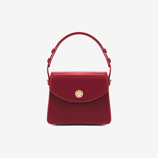 Kleine strukturierte Henkeltasche mit Überschlag in tiefem Rot, glatter Lederoptik, goldfarbenem Drehverschluss, kurzem Henkel und