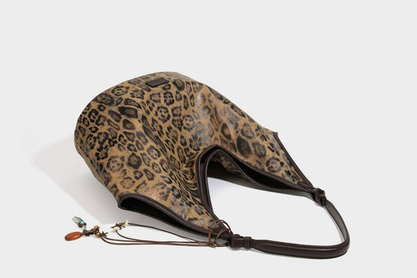Large slouchy leopard-print shoulder tote bag with glossy tan-and-brown finish, dark brown leather-look trim, single
