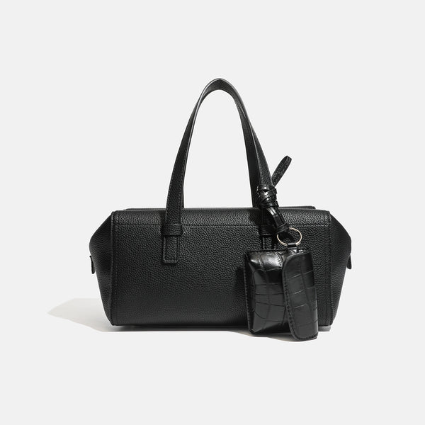 Structured pebbled leather-look top-zip barrel bag with dual handles, detachable shoulder strap, and attached croc-pattern
