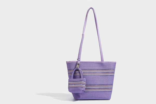 Large structured woven tote bag with striped basket-weave finish, long shoulder straps, and detachable mini pouch charm