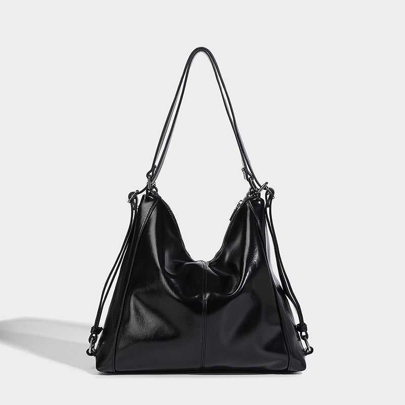 Glänzend schwarze, weich fallende Hobo-Tote-Bag mit silberfarbenem Kettenelement, Reißverschluss oben und langen Schulterriemen, Detailansicht 6