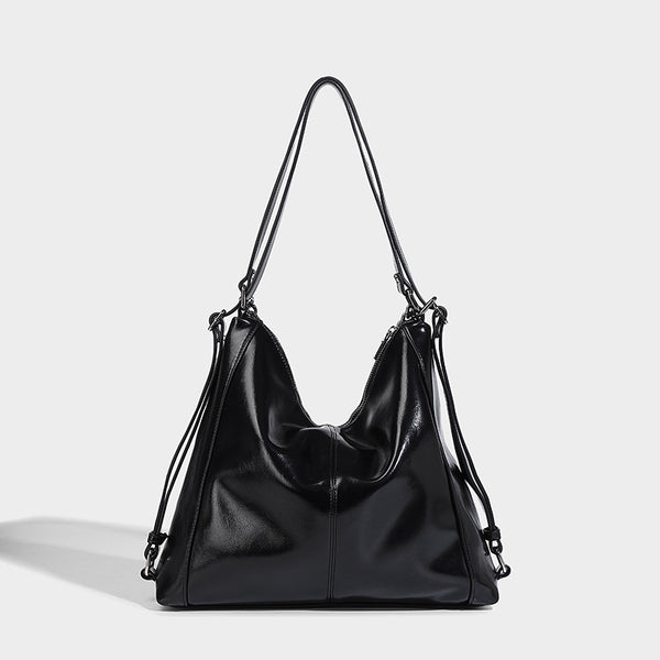 Glänzend schwarze, weich fallende Hobo-Tote-Bag mit silberfarbenem Kettenelement, Reißverschluss oben und langen Schulterriemen, Detailansicht 6