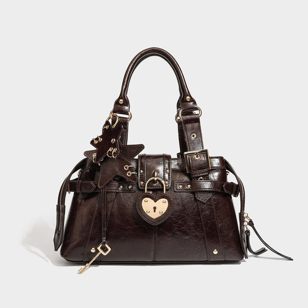 Strukturierte Boston-Henkeltasche in Espressobraun mit herzförmigem goldfarbenem Vorhängeschloss, Sternanhänger, Schnallenriemen, Nieten und zwei Henkeln oben