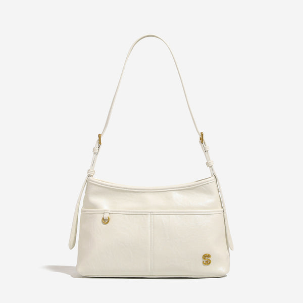 Relaxed leather-look shoulder tote bag in cream white with front exterior pocket, gold-tone ring hardware, and adjustable