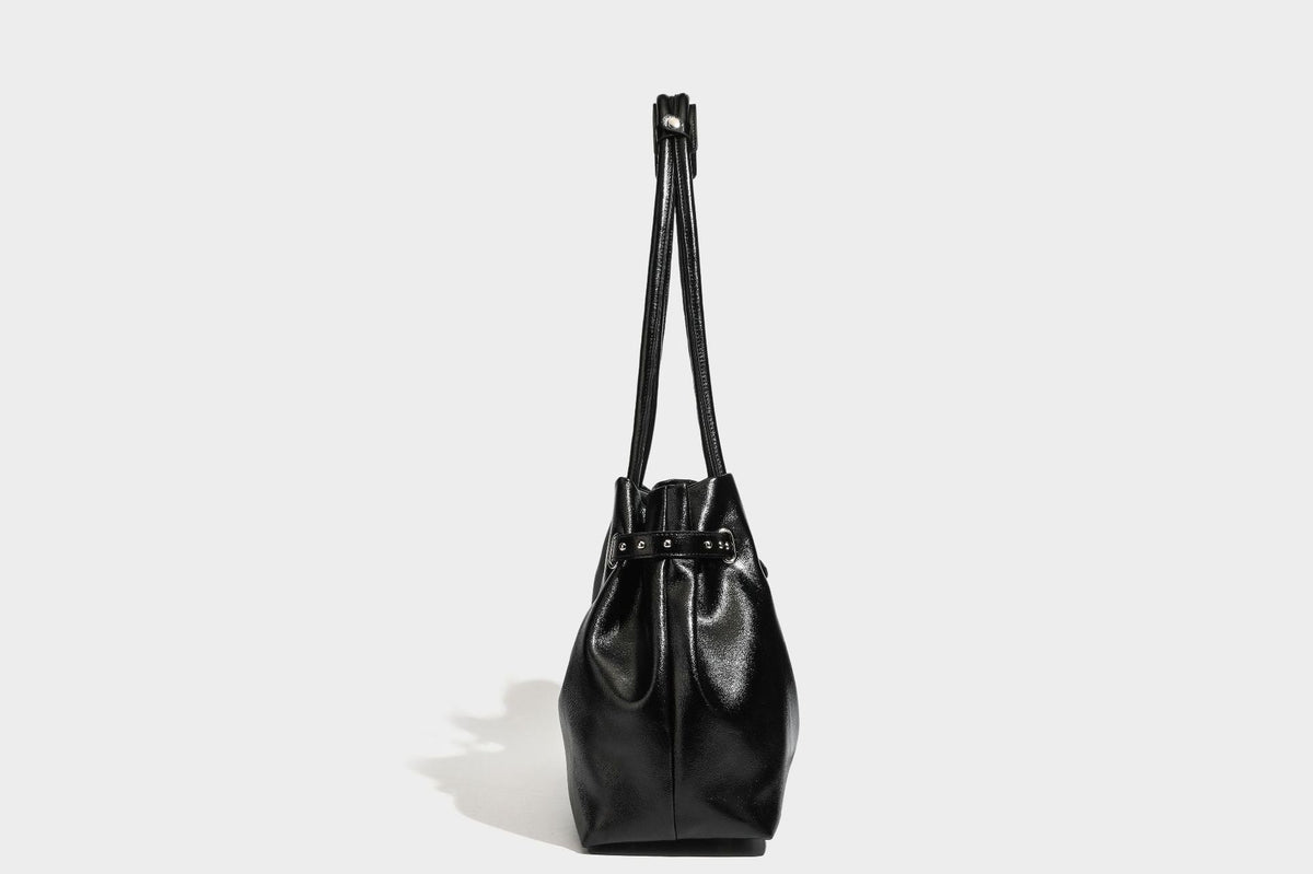 Glänzende schwarze, weich fallende Schultertasche mit gerafftem Abschluss, zwei langen Trageriemen, silberfarbenen Beschlägen und abnehmbarem Umhängeriemen