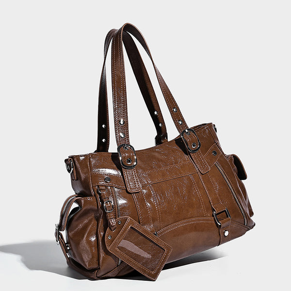 Glossy structured black tote shoulder bag with silver buckle hardware, zip pockets, dual top handles, and detachable, detail