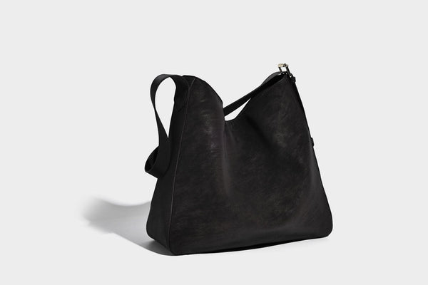 Large slouchy hobo shoulder bag in matte leather-look finish with adjustable strap and gold-tone bar hardware, detail view 23