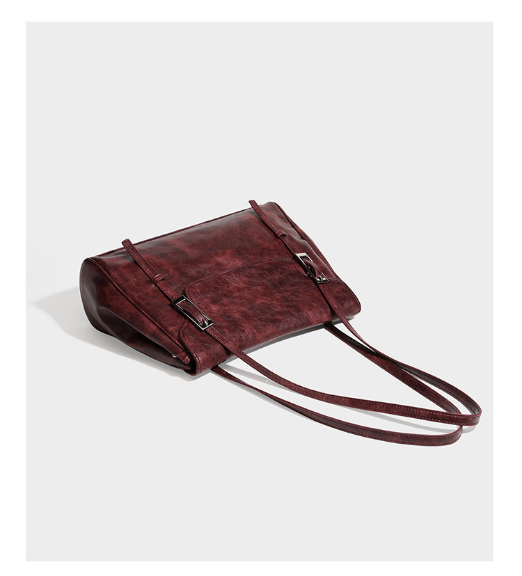 Large structured shoulder tote bag in wine red textured leather-look finish with front flap closure and silver-tone buckle