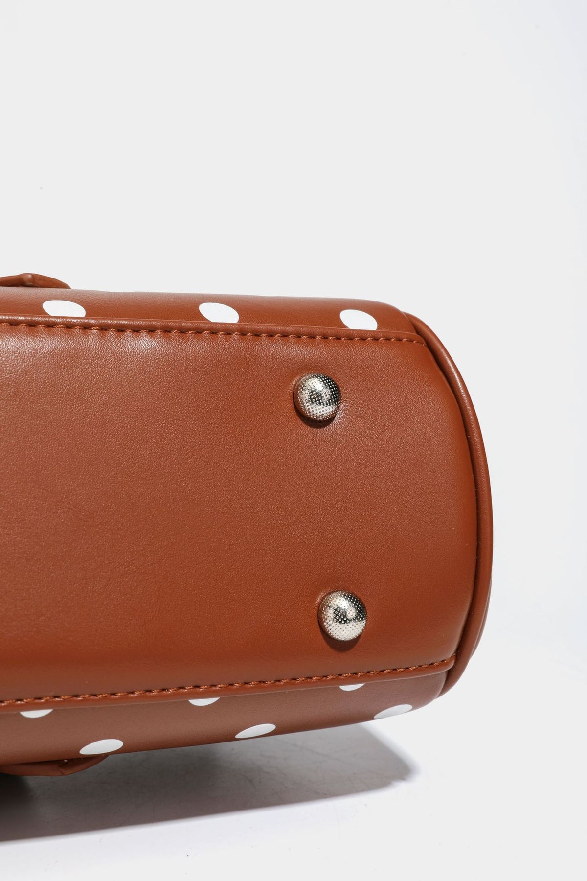 Strukturierte Baguette-Tasche mit Punktemuster in glänzender Lederoptik, zwei Tragegriffen, Überschlag mit Drehverschluss in Silberoptik und