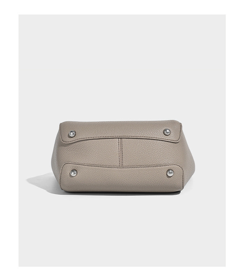 Structured pebbled leather-look tote bag with detachable scarf tie, dual top handles, and adjustable crossbody strap, detail