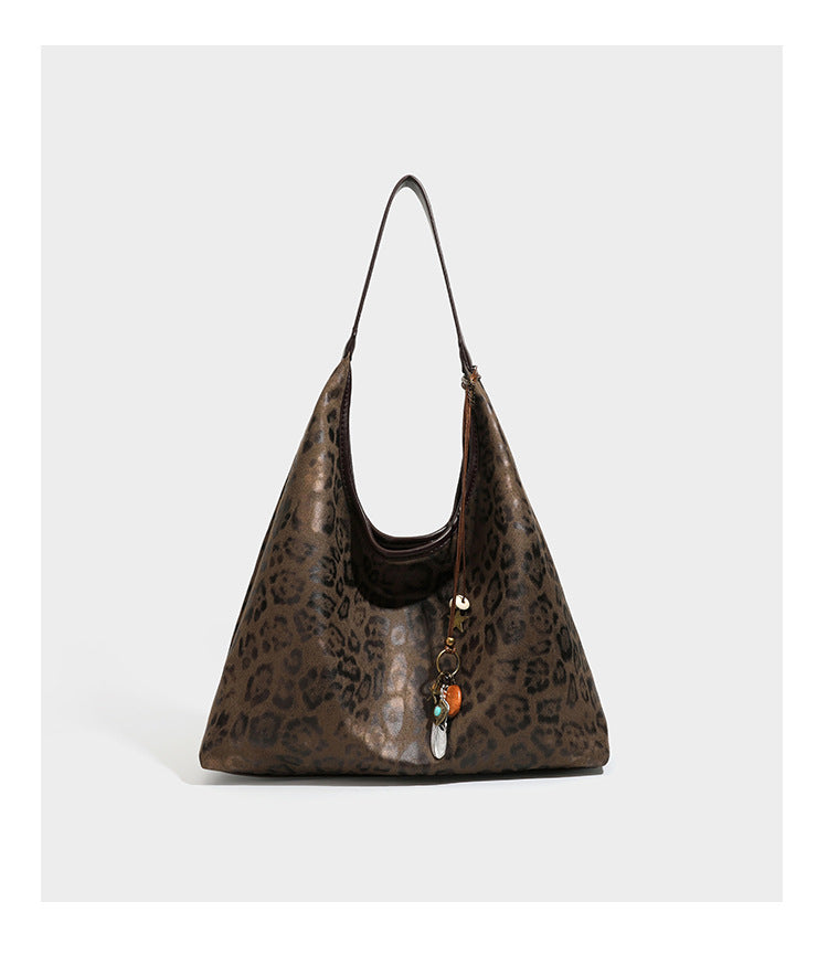 Weich fallende Hobo-Tote-Bag mit Leopardenmuster in Beige und Braun, dunkelbraunem Riemen in Lederoptik und herabhängenden Perlenanhänger-Beschlägen