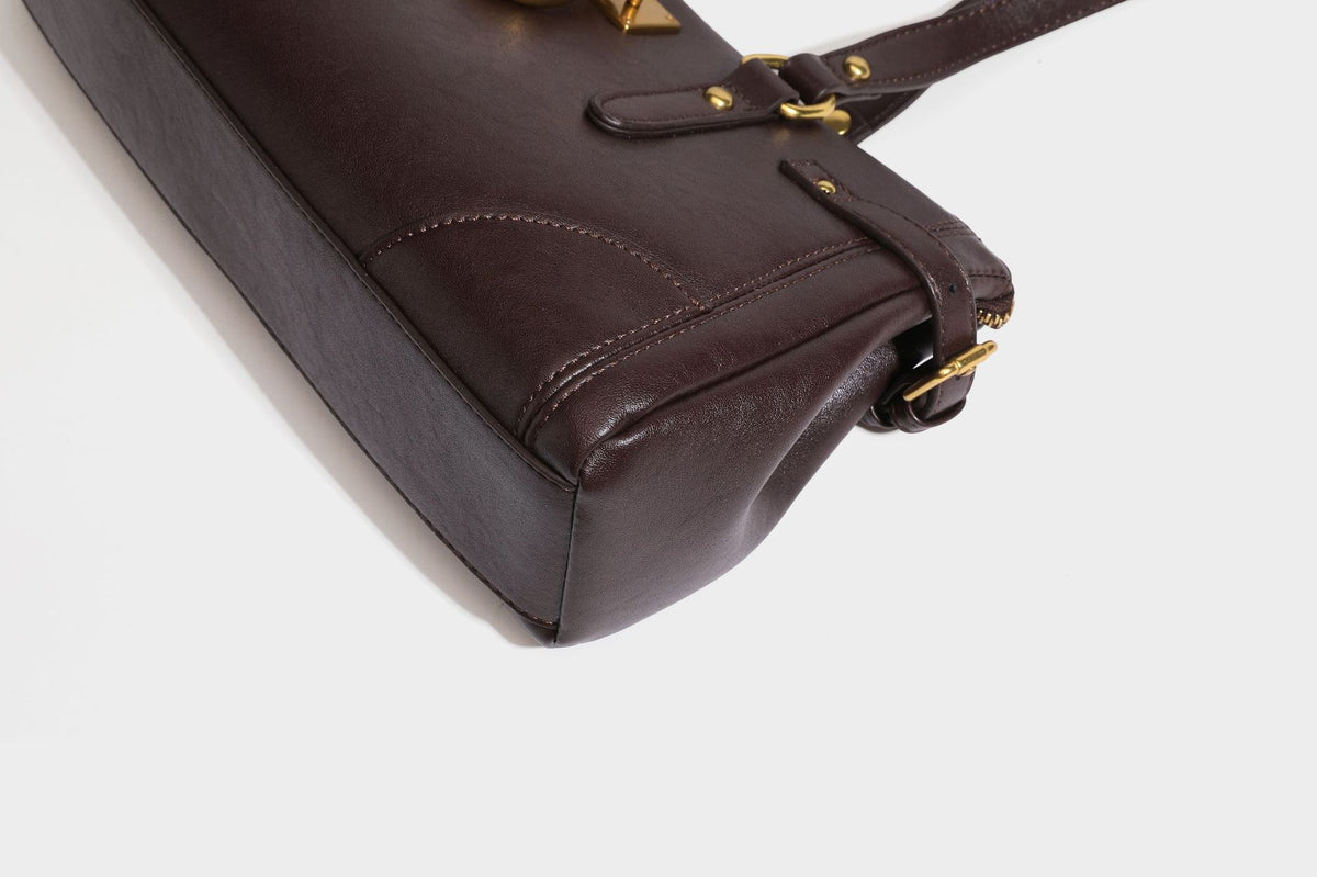 Strukturierte dunkelbraune Satchel-Tote in Lederoptik mit Ringverschluss in Antikgold-Optik, zwei Henkeln und seitlichem Riemen mit Schnalle