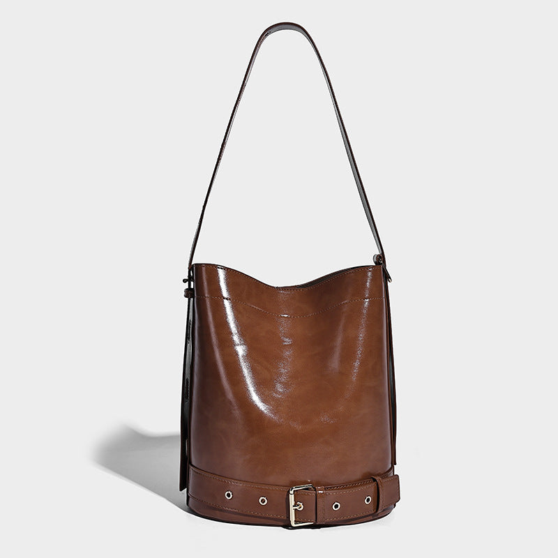 Glänzende Bucket-Bag in Lederoptik mit umlaufendem Riemen, silberfarbenen Ösen und verstellbarem Schulterriemen, Detailansicht 3