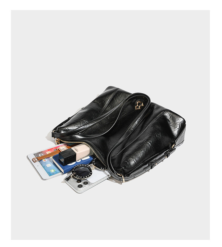 Große, lässig fallende Hobo-Schultertasche in glänzender, geknautschter Lederoptik mit goldfarbenen Beschlägen und langem, verstellbarem Riemen