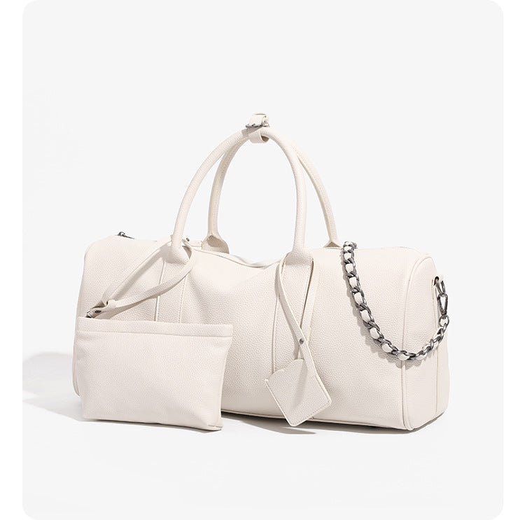 Large cream white pebbled leather-look barrel travel bag with twin top handles, chunky chain shoulder strap, front zip