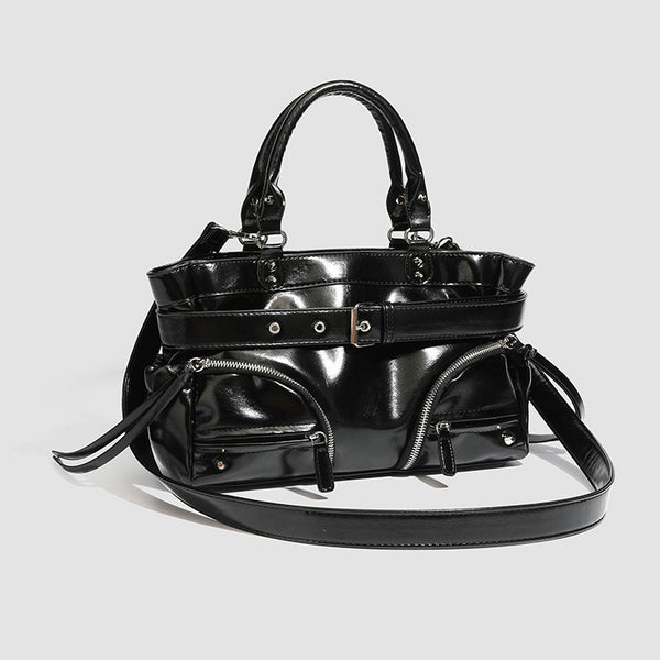 Black glossy structured tote bag with rivet and buckle detail, dual top handles, and detachable shoulder strap, detail view 2