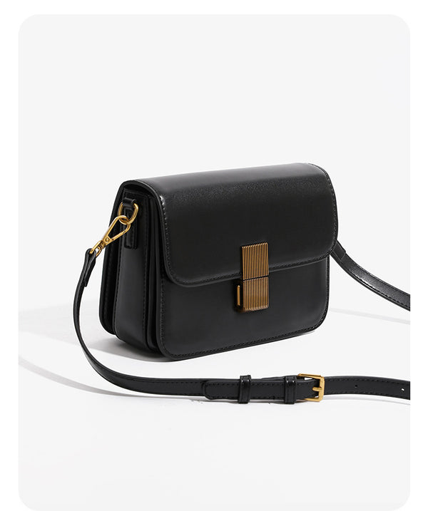 Mini structured black flap crossbody bag with gold-tone ribbed rectangular clasp and adjustable shoulder strap, detail view 7