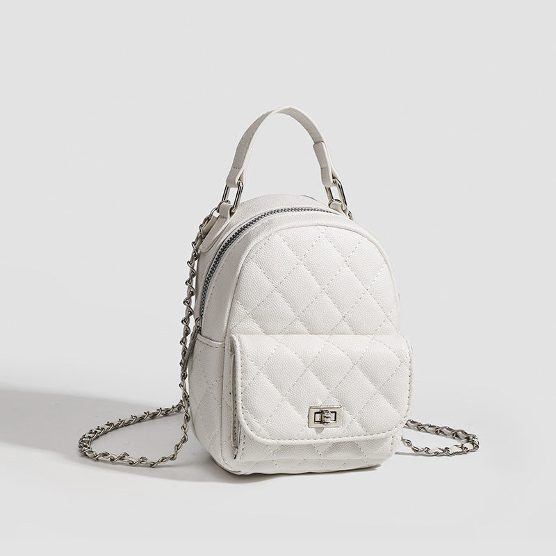 Compact diamond-quilted mini backpack handbag with silver-tone chain straps and turn-lock front pocket, detail view 3
