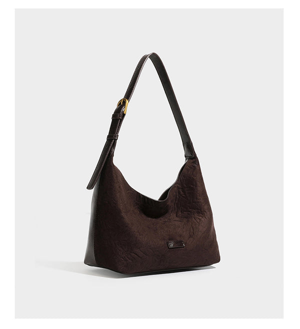 Dunkelbraune, lässig fallende Hobo-Schultertasche mit velourslederähnlich strukturierter Oberfläche, glatter lederähnlicher Paspelierung und Details in Antikgoldoptik, Detailansicht