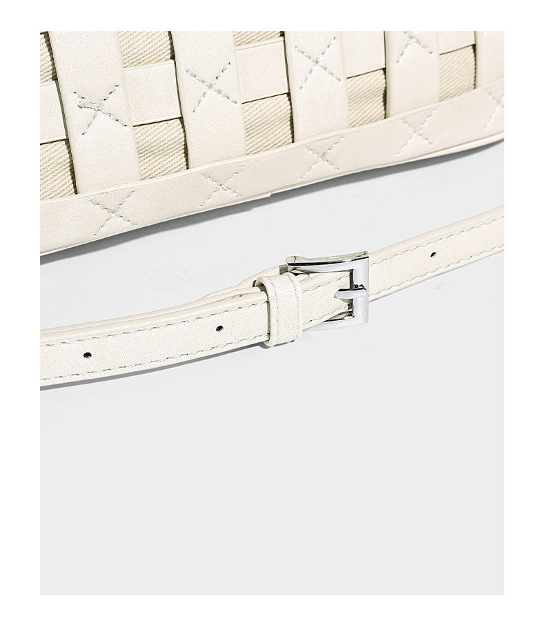 Small structured woven satchel tote with rounded top handles, silver-tone ring hardware, and bead tassel charm, detail view
