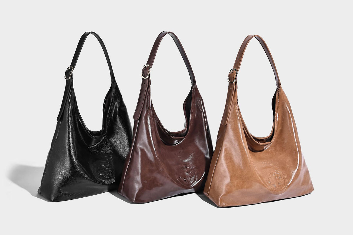 Glossy slouchy hobo shoulder bag with adjustable strap and embossed floral emblem, detail view 9