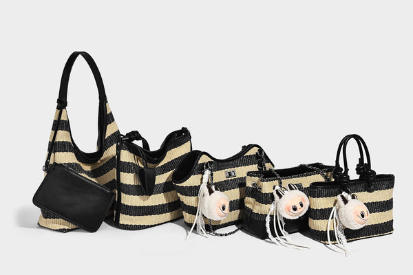 Gestreifte gewebte Bucket Bag in Schwarz und Beige mit schwarzem Besatz in Lederoptik, offener Oberseite und langem verstellbarem Schulterriemen, Detailansicht