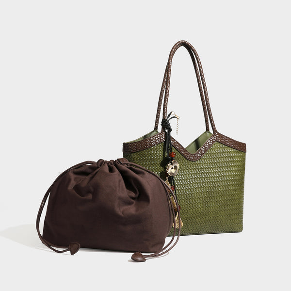 Olivgrüne Tote-Bag in Korbgeflecht-Optik mit dunkelbraunen geflochtenen Schulterriemen, seitlichen Zugbändern und Perlenanhänger in Goldoptik