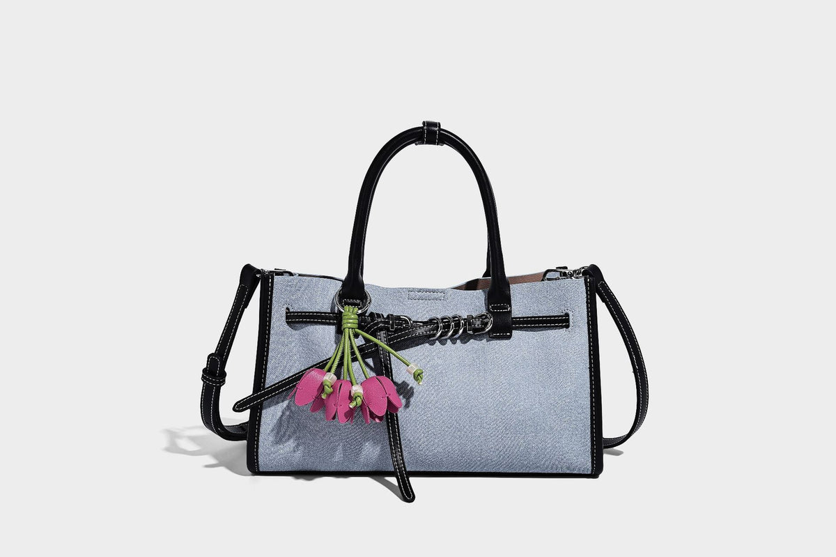 Structured rectangular tote satchel in denim-look fabric with dark trim, knotted front strap hardware, and detachable, detail