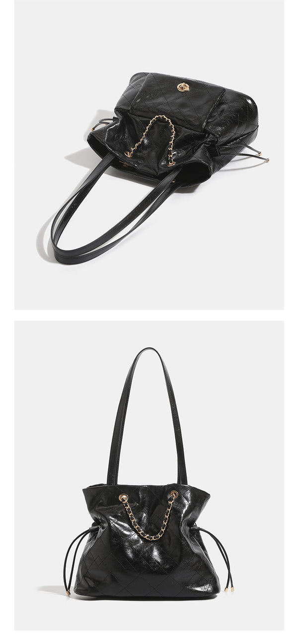 Black glossy diamond-quilted bucket tote bag with gold-tone chain accent, turn-lock front flap pocket, drawstring side ties