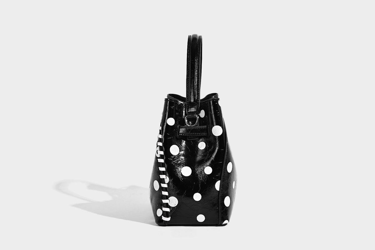 Glänzende, geknautschte Beuteltasche mit Polka-Dots, silberfarbenen Schnallenbeschlägen, kontrastierendem seitlichem Schnürbesatz, Tragegriff und abnehmbarem