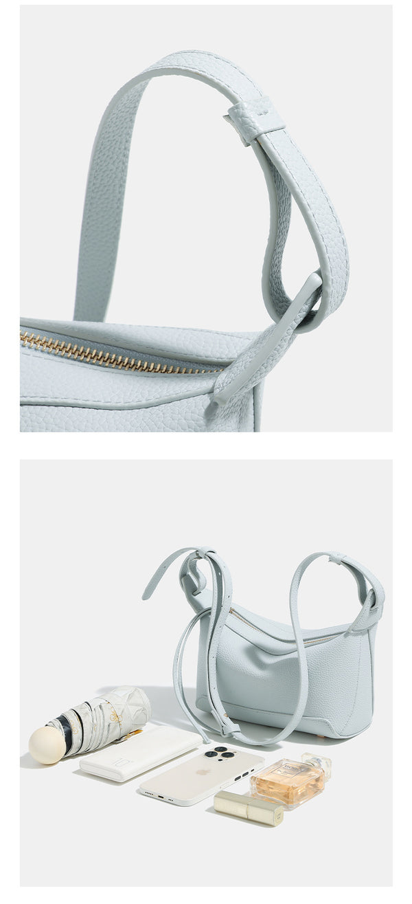 Small structured mini crossbody shoulder bag with pebbled texture, knotted adjustable strap, top zip closure, and gold-tone