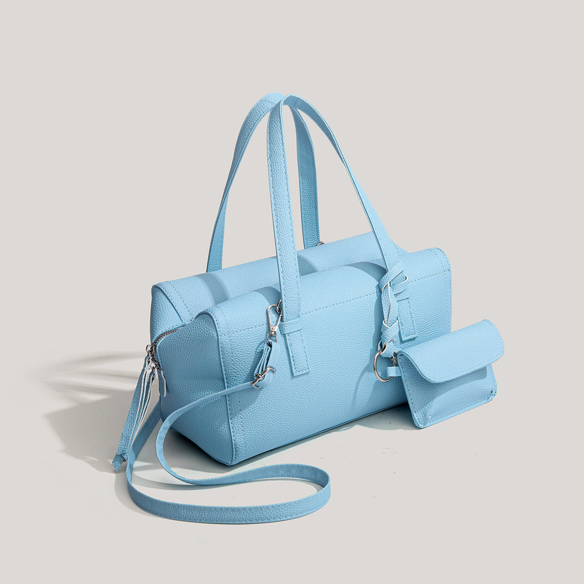 Light blue pebbled matte Boston tote bag with top handles, detachable shoulder strap, metal ring hardware, and matching mini