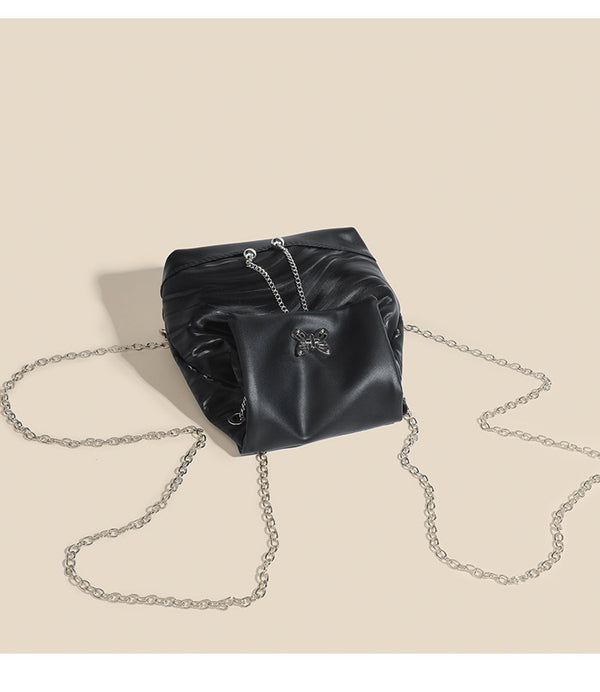 Compact ripple-embossed leather-look backpack handbag with silver butterfly clasp and chain straps, detail view 10