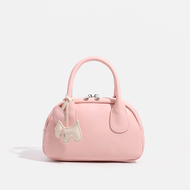 Mini-Handtasche in Kuppelform mit glatter Oberfläche in Lederoptik, zwei Tragegriffen, Reißverschluss oben, Beschlägen in Silberoptik und herabhängendem
