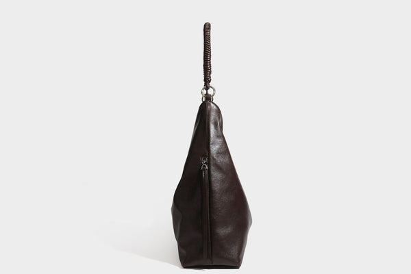 Large slouchy hobo shoulder bag with braided top handle, smooth glossy leather-look finish, and silver-tone ring hardware