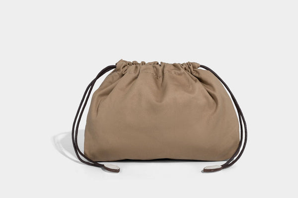 Structured woven basket tote handbag with contrasting dark trim, double top handles, detachable shoulder strap, and