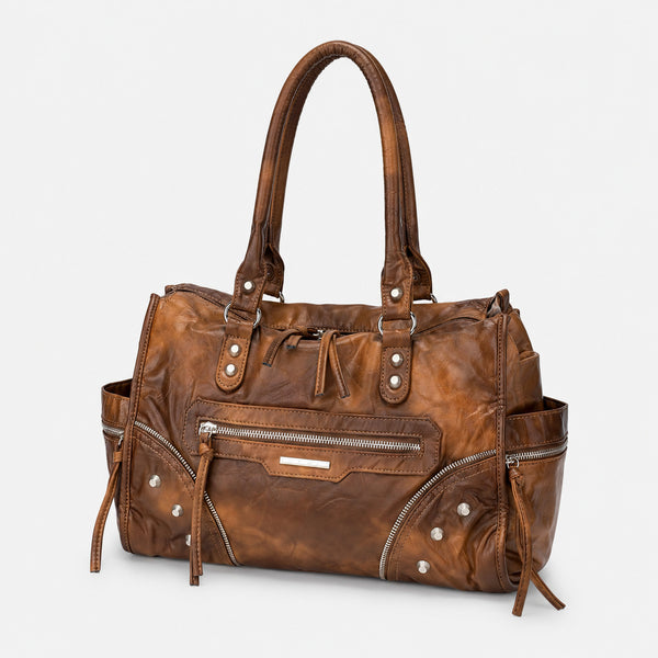 Large distressed leather-look moto tote bag with silver rivets, tassel zip pulls, front zip pocket, and dual top handles