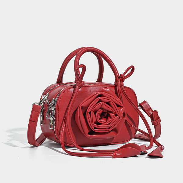 compact barrel bag with 3D rose appliqué, dual zip top, knotted handle, and adjustable crossbody strap, detail view 3