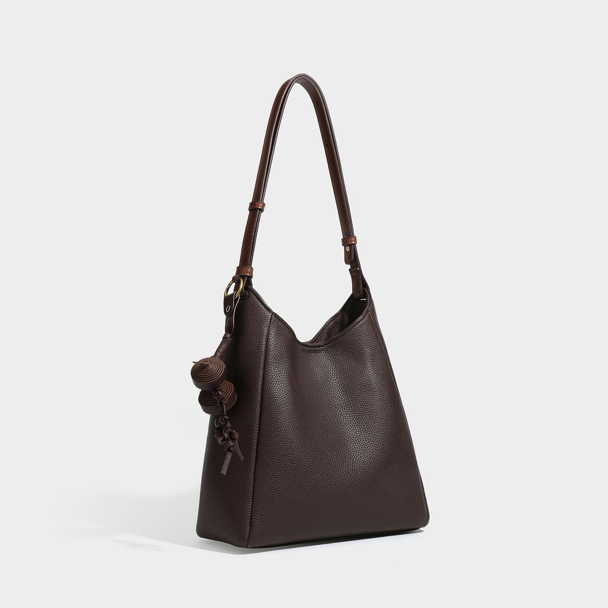 Dunkel espressofarbene Hobo-Schultertasche in genarbter Optik mit warm cognacfarbenem Besatz, verstellbarem schmalem Riemen, goldfarbenen Ringbeschlägen und geknotetem