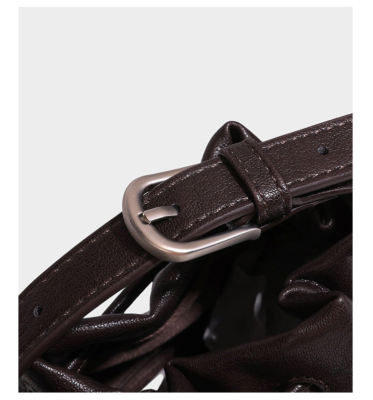 Kleine dunkelbraune Beuteltasche mit Kordelzug, langem verstellbarem Crossbody-Riemen und silberfarbenen Beschlägen, Detailansicht 20