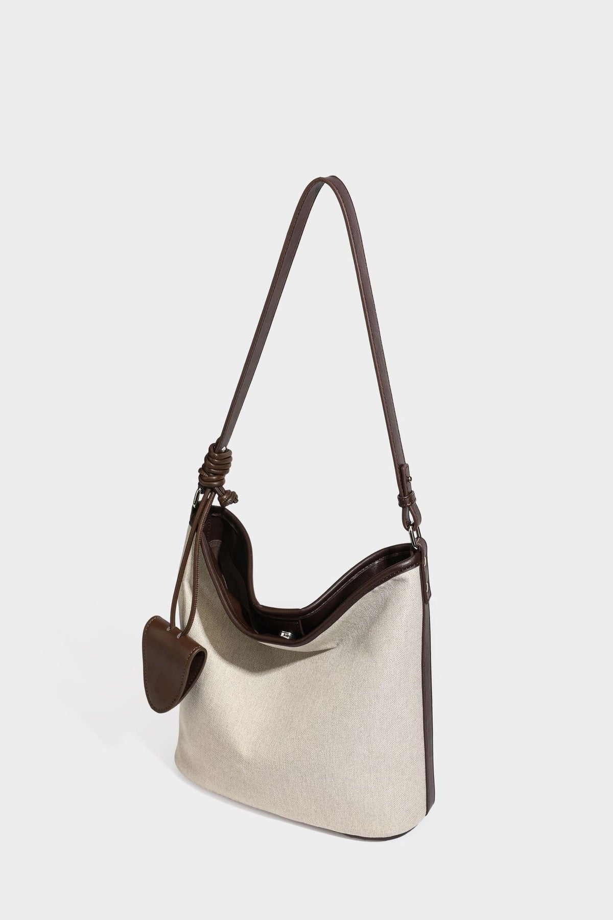 Oatfarbene Canvas-Schultertasche mit dunkelbraunem Besatz in Lederoptik, langem verstellbarem Riemen und angebrachter Mini-Tasche mit Überschlag, Detailansicht