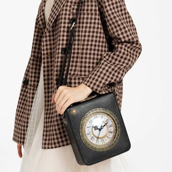 Small structured rectangular crossbody bag with ornate antique-style clock face and brass hardware in, front view
