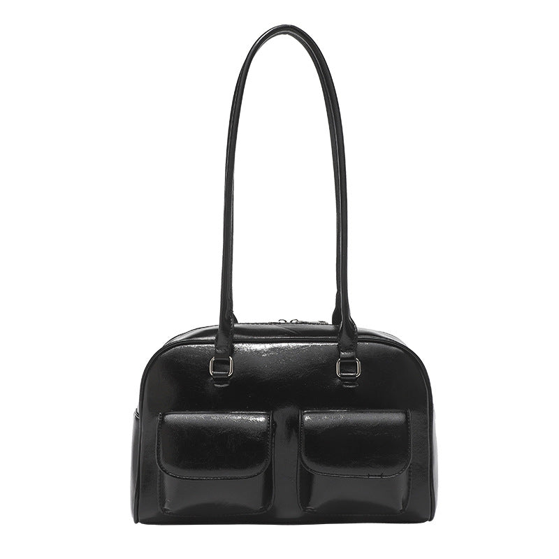 Structured glossy leather-look bowling shoulder bag with two front flap pockets, top zip closure, and long double shoulder