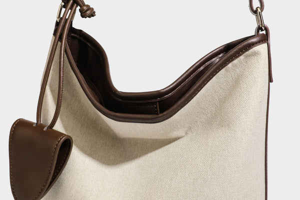 Oatfarbene Canvas-Schultertasche mit dunkelbraunem Besatz in Lederoptik, langem verstellbarem Riemen und angebrachter Mini-Tasche mit Überschlag, Detailansicht