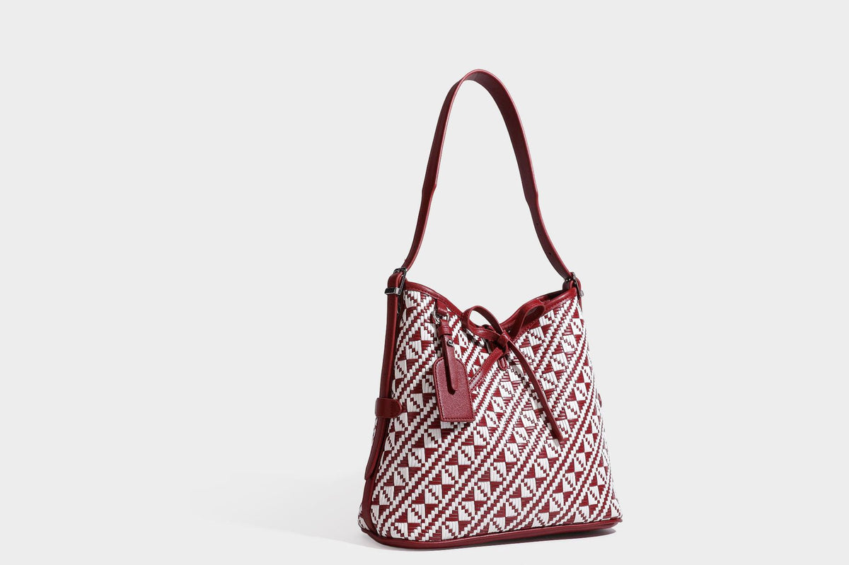 Woven geometric bucket shoulder bag in white and dark brown two-tone pattern with leather-look trim and drawstring top