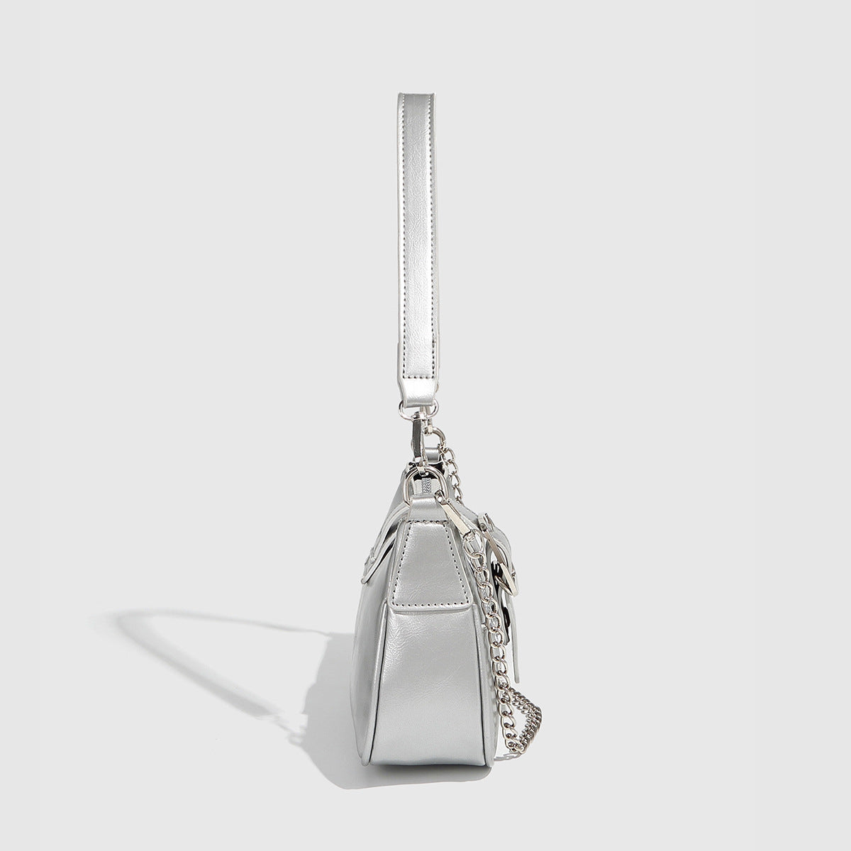 Compact metallic silver shoulder bag with glitter star appliqués, rhinestone star charms, front belt buckle strap, chunky