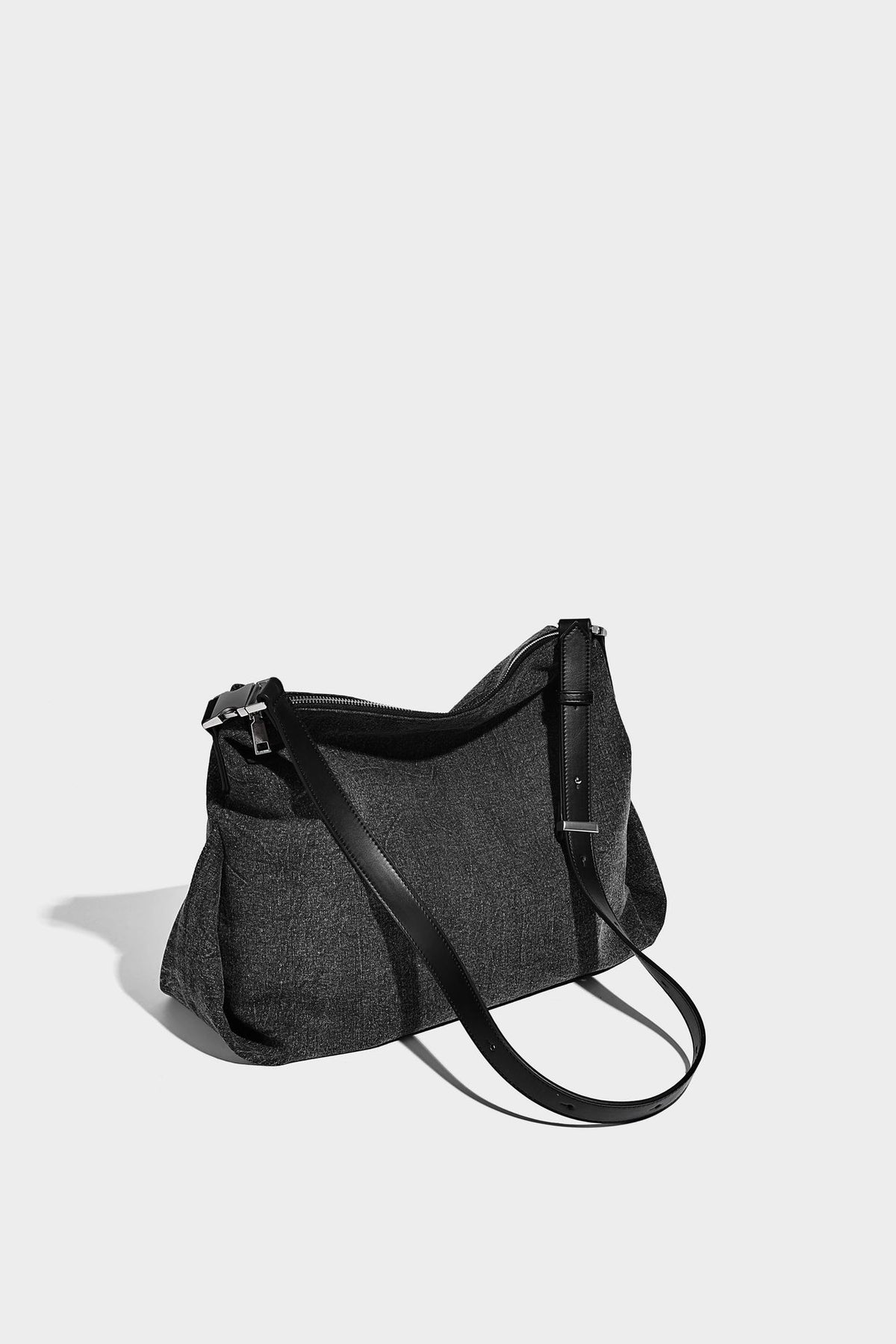 Charcoal denim-textured slouchy hobo bag with zip-top closure, silver-tone hardware, and adjustable leather-look crossbody